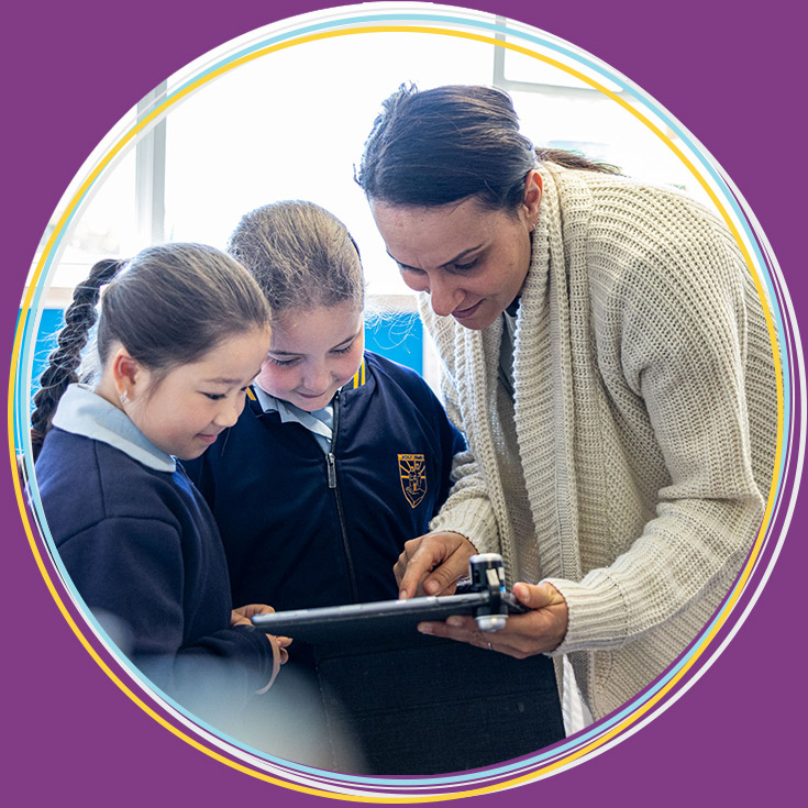 Teacher assisting students at Holy Family Catholic Primary East Granville