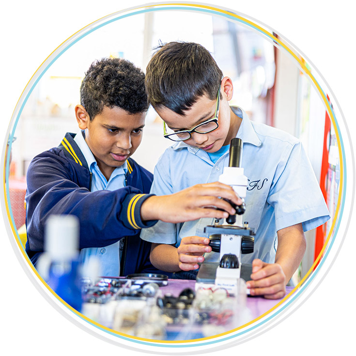 Boys using a microscope at Holy Family Catholic Primary East Granville