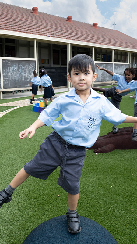 Stage 1 student at Holy Family East Granville playing on playground equipment