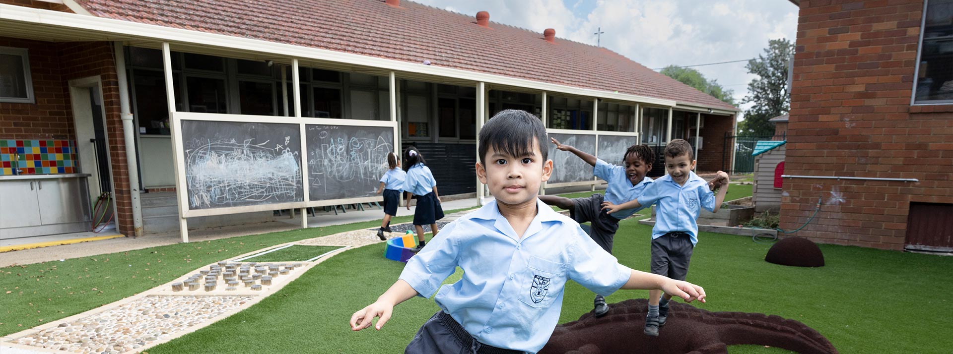 Stage 1 student at Holy Family East Granville playing on playground equipment