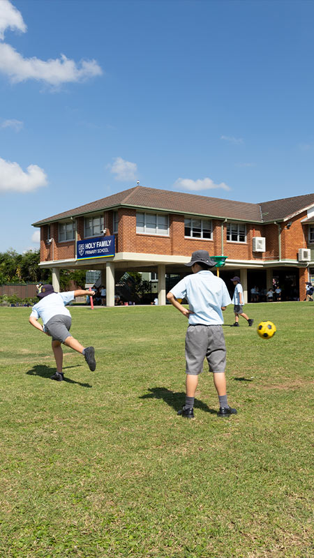 Students playing on the outdoor field at Holy Family Granville