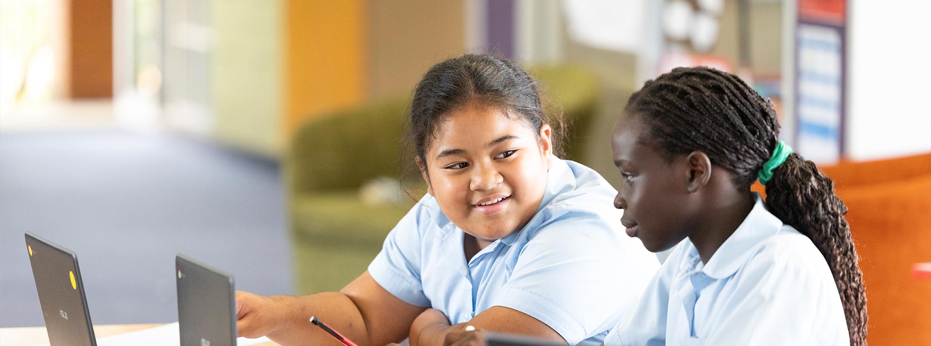 Two Holy Family Primary, East Granville students in class and using laptops