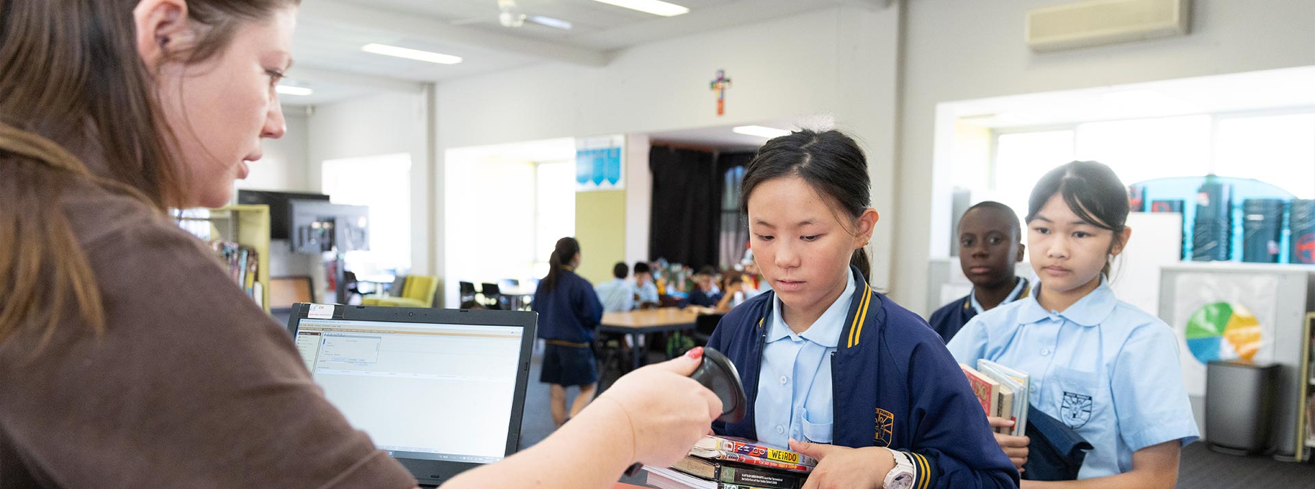Student borrowing books at Holy Family East Granville primary school library