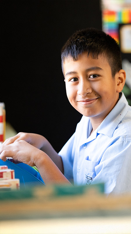 Holy Family Primary East Granville student picking out a library book to read