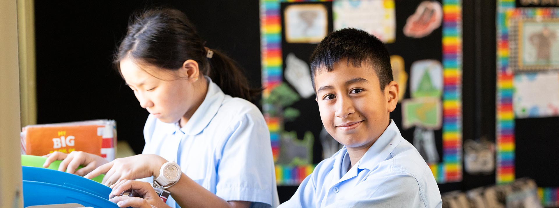 Holy Family Primary East Granville student picking out a library book to read