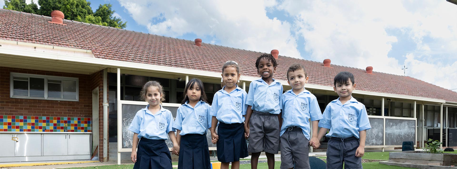 Kindergarten students at Holy Family Primary, East Granville standing atop playground equipment