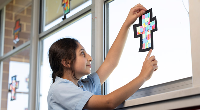 Holy Family Primary, East Granville students hanging up Catholic art