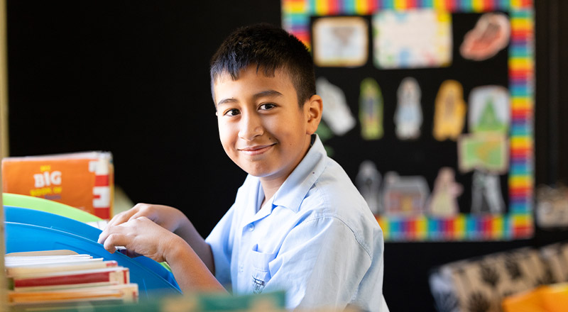 Holy Family Primary East Granville student picking out a library book to read