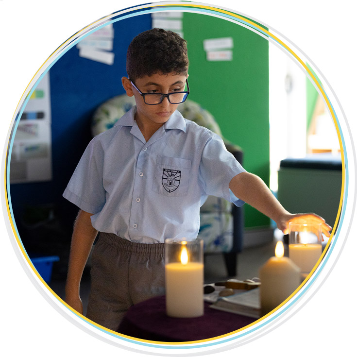 Holy Family Primary, East Granville student lighting prayer candle