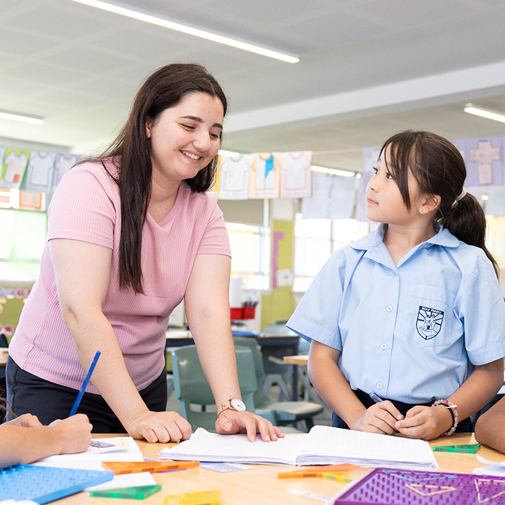 Teacher assisting students at Holy Family Primary, East Granville