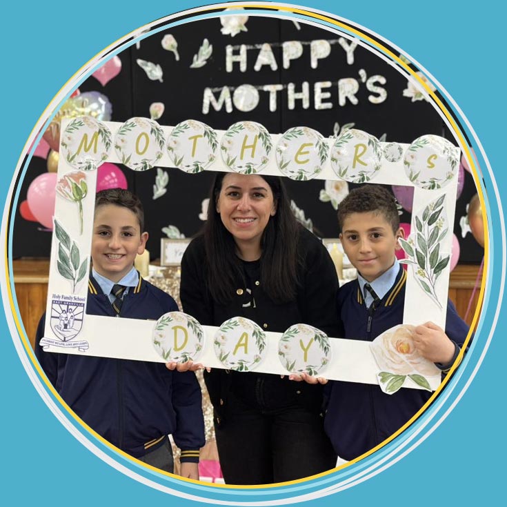 Mother and two sons at Holy Family Primary Granville East holding a banner which reads Mother's Day